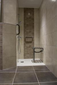 La salle de bains est pourvue d'une douche avec une porte en verre. dans l'établissement Hôtel Karène, à Saint-Paul-lès-Romans