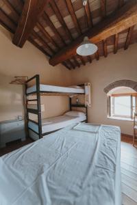 a bedroom with two bunk beds and a window at Ostello Bello Assisi Bevagna in Bevagna