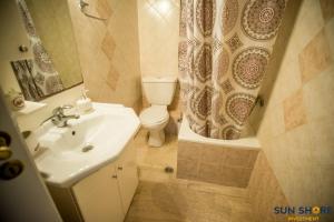 a bathroom with a sink and a toilet and a shower curtain at Explore Greece from Close the Sea Apartment in Chalkida