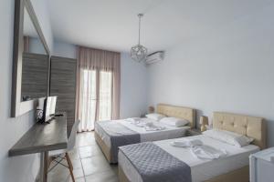 1 dormitorio con 2 camas, mesa y ventana en STRAWBERRY Skiathos en Agia Paraskevi