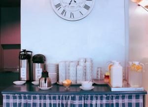 a clock on a wall above a counter with appliances at Center Hotel in Tallinn