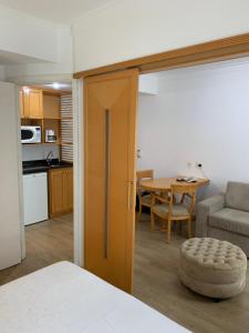 a room with a kitchen and a table with a couch at Charmoso Flat em Pinheiros in Sao Paulo