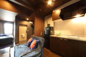 uma pequena cozinha com um sofá num quarto em s-rea TOKYO301 em Tóquio