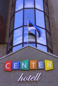 a sign on top of a building with a flag at Center Hotel in Tallinn