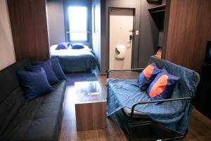 una sala de estar con un sofá y una cama en s-rea TOKYO301, en Tokio