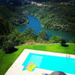 a swimming pool with a view of a lake at Quinta das Tílias Douro Valley in Cabaça