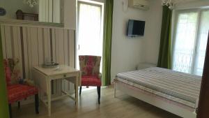 a bedroom with a bed and a table and two chairs at Rooms Villa Harmonie - Adults Only +14 in Crikvenica