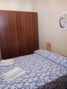 a bedroom with a bed with a blue and white bedspread at Mediterraneo Appartaments 2 in Lampedusa
