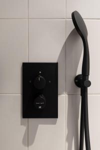 a black electrical outlet on a white tiled wall at Conscious Hotel Museum Square in Amsterdam