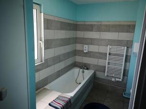 ein Bad mit einer Badewanne und einem Fenster in der Unterkunft Hôtel Triotel in La Valette-du-Var