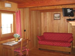 Una sala de estar con un sofá rojo y una mesa. en L'Etoile Du Berger, en Lillianes