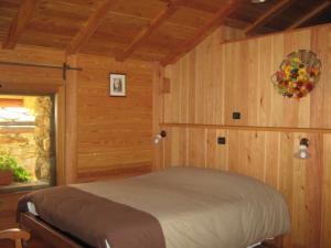 Un dormitorio con una cama en una habitación de madera. en L'Etoile Du Berger, en Lillianes