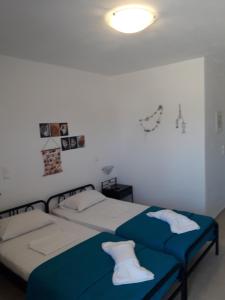 a bedroom with two beds with blue and white sheets at Vigles in Adamantas