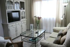 sala de estar con TV y mesa de cristal en Barlovento 41 en Mocanal