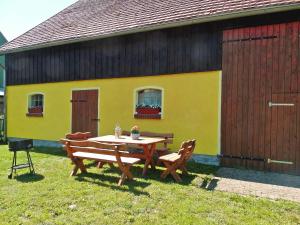 a table and chairs in front of a yellow building at Ferienhaus mit 3 Schlafraeumen Vor in Woldegk