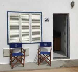 Apartamento las Crucetas في كاليتا دي سيبو: كرسيان زرقان يجلسون أمام المبنى