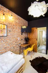 een slaapkamer met een bakstenen muur, een bed en een bureau bij Retro Apartments in Rzeszów