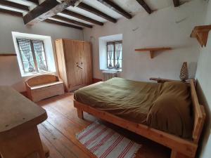 a bedroom with a large bed and two windows at Casa in sasso - Pietra di Bismantova in Castelnovo neʼ Monti