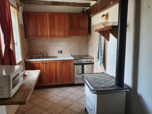 a kitchen with wooden cabinets and a stove top oven at Casa in sasso - Pietra di Bismantova in Castelnovo neʼ Monti
