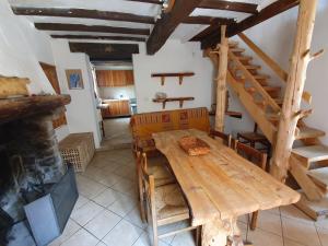 une salle à manger avec une table en bois et des escaliers dans l'établissement Casa in sasso - Pietra di Bismantova, à Castelnovo neʼ Monti