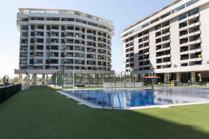 ein Gebäude mit zwei hohen Gebäuden und einem Pool in der Unterkunft ApartUP Patacona Palm Beach I in Valencia