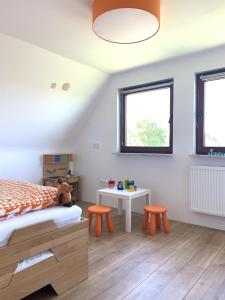 ein Schlafzimmer mit einem Bett, einem Tisch und zwei Hockern in der Unterkunft Haus Plüschmors in Garding