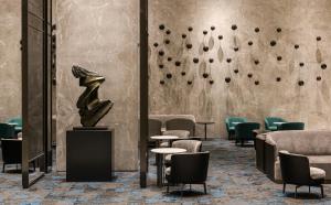 台南市にあるLakeshore Hotel Tainanの椅子と壁に彫刻が飾られたロビー