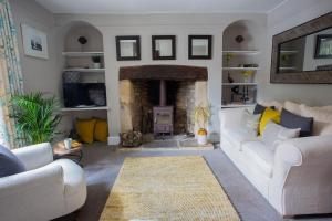 a living room with a white couch and a fireplace at No. 14, Park Street in Stow on the Wold