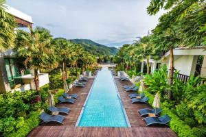 una piscina infinita en un complejo con sillas y palmeras en Wyndham Sea Pearl Resort, Phuket, en Patong Beach