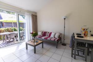 een woonkamer met een bank en een tafel bij Village Beauséjour - Rêves de mer in Le Conquet
