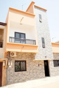 a building with a balcony on the side of it at Quintal di Maria in Guediawaye