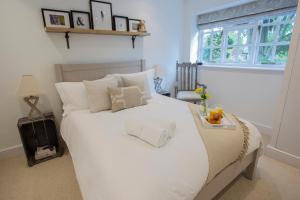 a white bed in a room with a window at No. 14, Park Street in Stow on the Wold