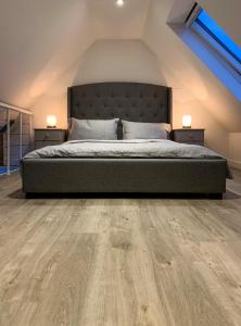 a bedroom with a bed and wooden flooring at Balloan Cottage in Inverness