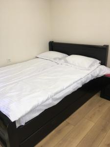 ein Bett mit weißer Bettwäsche und Kissen darauf in der Unterkunft 10 shindisi street,Tbilisi in Tbilisi City