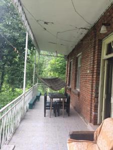 a hammock on the porch of a house at GuestHouse Malkhazi in Borjomi