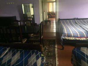 a room with two beds and a table and a dining room at GuestHouse Malkhazi in Borjomi