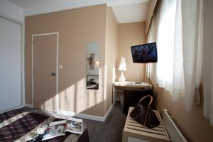 Televízia a/alebo spoločenská miestnosť v ubytovaní Hôtel Karène