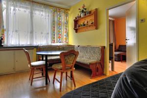 een woonkamer met een tafel en stoelen en een bank bij Apartments Letna in Praag