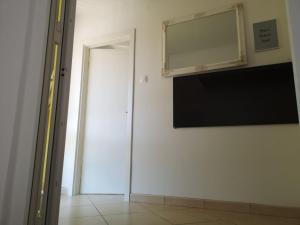a room with a television and a mirror on the wall at Odisey in Postojna