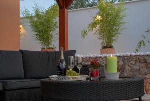 een tafel met een fles wijn en wijnglazen bij Villa Village Idylle with heated pool, sauna, jacuzzy and private parking in Sukošan