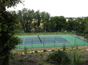 Una pista de tenis con raqueta. en Villa Mas, en Cestayrols