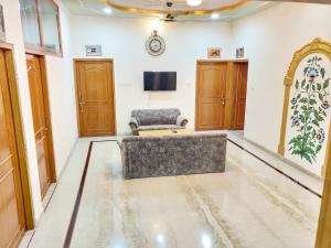 - un salon avec un canapé et une télévision dans l'établissement Ranthambore Tiger Home, à Sawai Madhopur