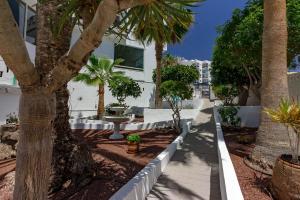 un trottoir avec des palmiers et un bâtiment dans l'établissement LA ESTRELLA 1A020, à Los Cristianos