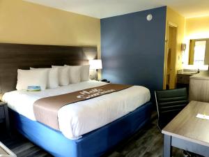 a hotel room with a large bed and a table at Days Inn by Wyndham Cleveland TN in Cleveland