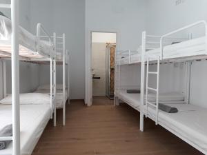 a room with three bunk beds and a hallway at Hub Hostel Seville in Seville +19 photos