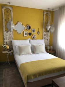 a bedroom with a large bed with a yellow wall at Casa do Castelo in Sernancelhe