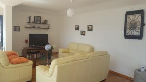 uma sala de estar com duas cadeiras e uma televisão em V.I.P. Baia em Machico