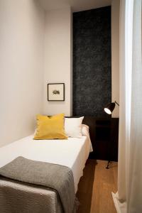 a bedroom with a bed with a yellow pillow at Casa Noa Apartments in Seville