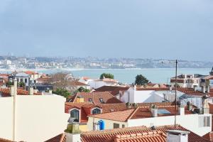 a view of roofs of houses and the water at Ninho Salino in Cascais