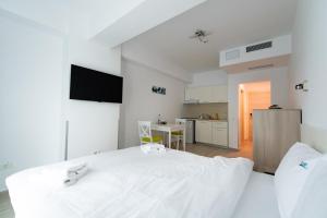 a white room with a bed and a kitchen at ZIP Apartments in Mamaia